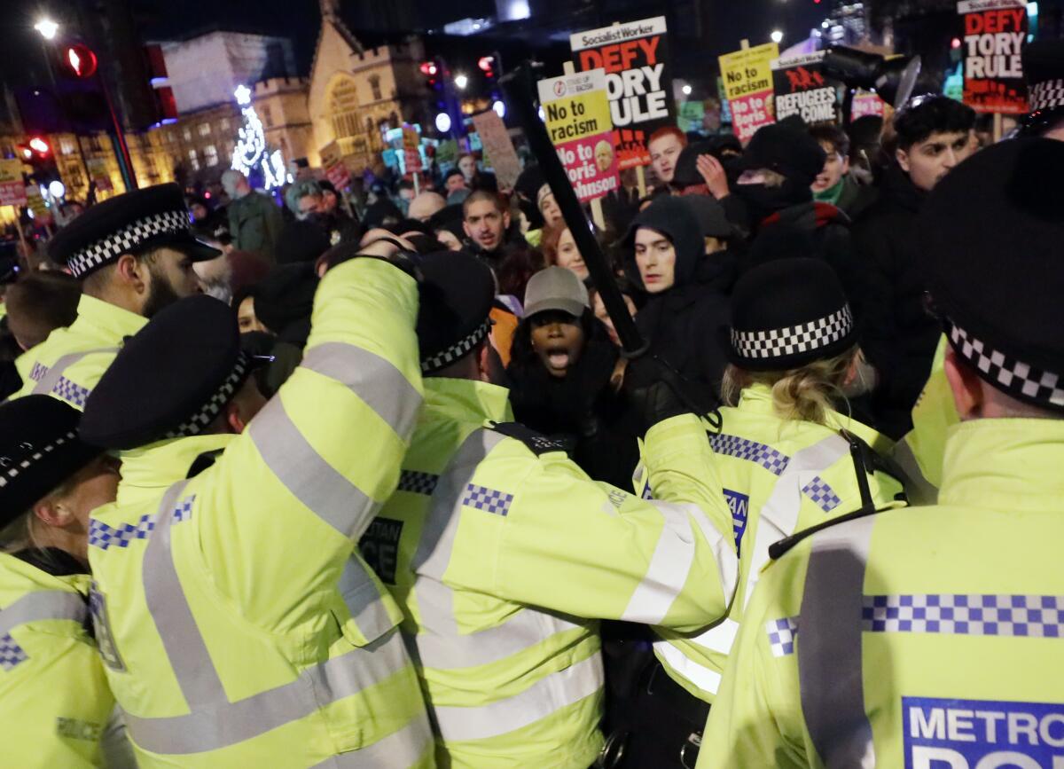People scuffle with police during an anti-Boris Johnson demonstration, at Trafalgar Square in central London, Friday Dec. 13, 2019.
