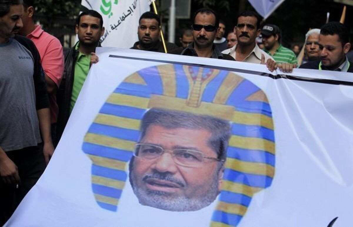 Egyptian protesters hold a banner depicting Egyptian President Morsi as a pharaoh in Cairo. Last week Morsi announced that his rule was immune to judicial oversight of any kind.