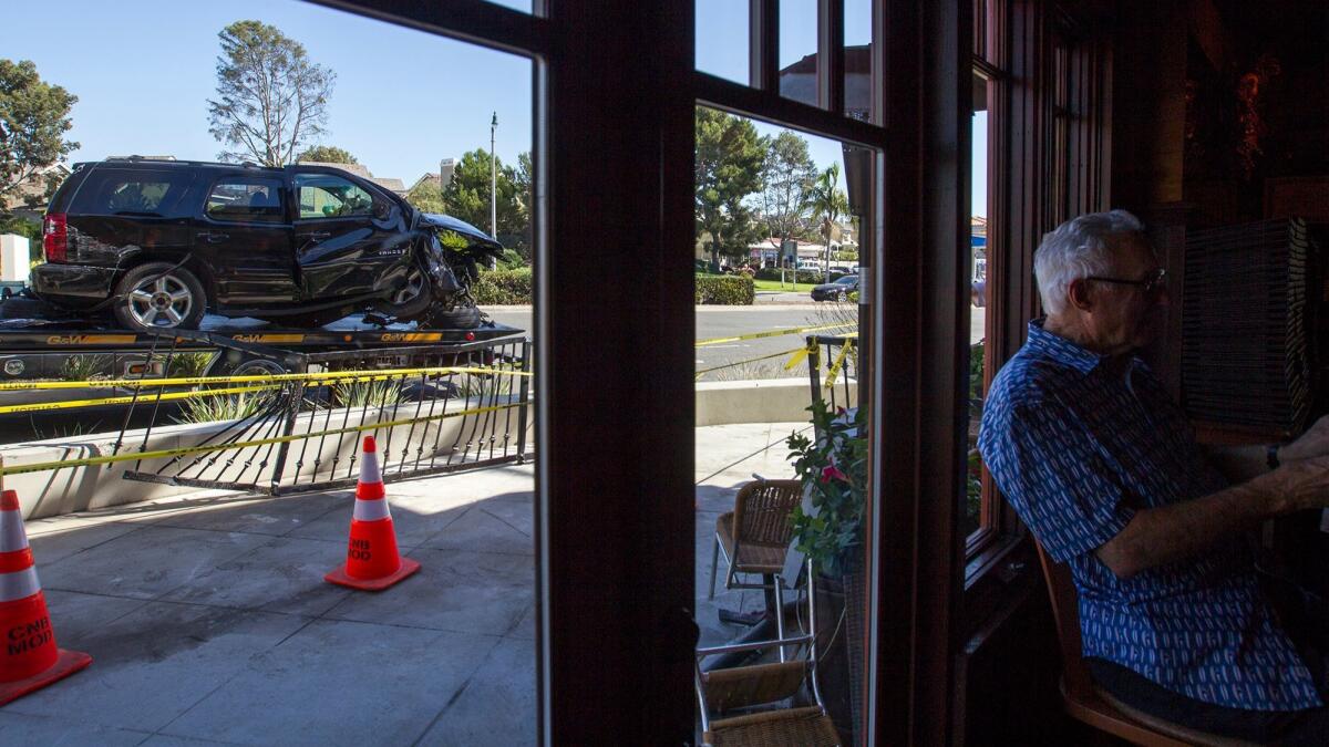 A customer sits inside The Bungalow Restaurant on Tuesday after an SUV crashed into the patio area outside.