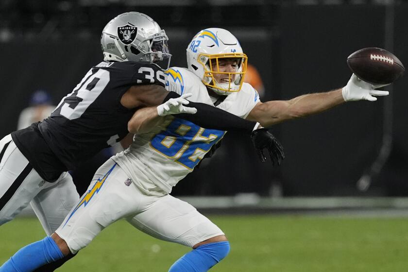 Las Vegas Raiders cornerback Nate Hobbs, left, breaks up a pass intended for Chargers wide receiver Alex Erickson.
