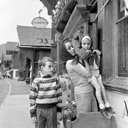 Elizabeth Taylor with two of her children next to an antiques store in Gstaad, Switzerland. Even in casual moments, she was unmistakably a star. Taylor once said that women who do not wear silk scarves are futureless.