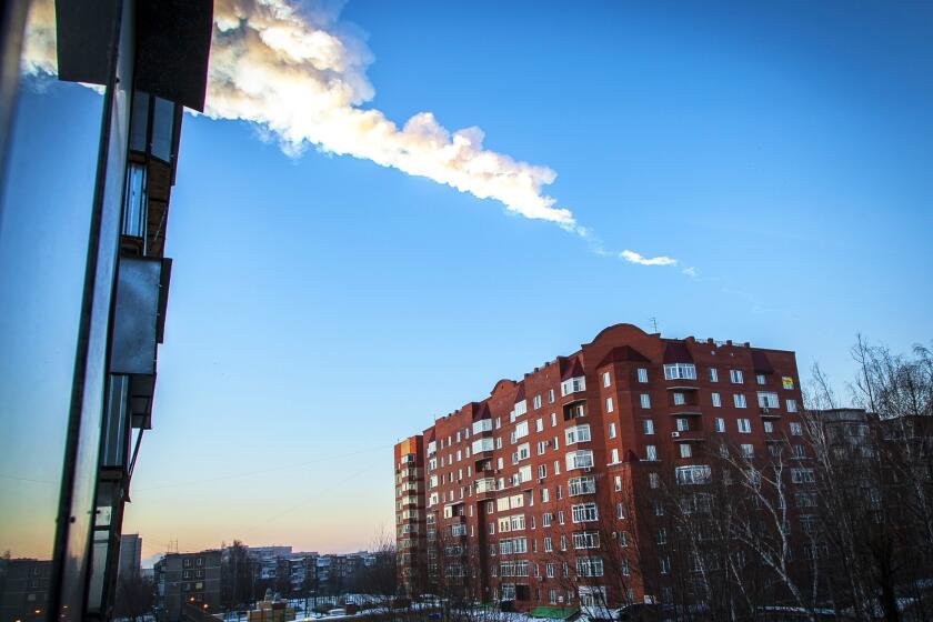 A meteorite trail seen above a residential apartment block in the Urals city of Chelyabinsk, Russia.