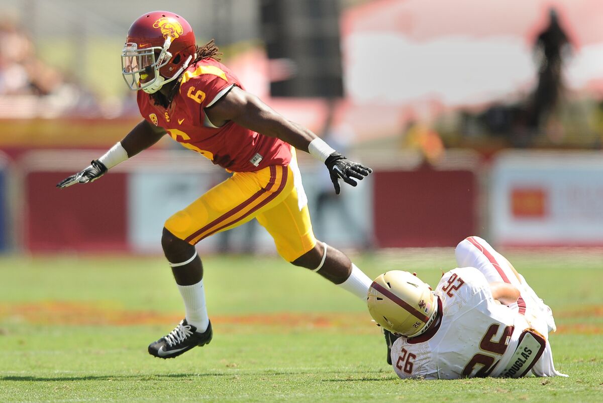 USC's Josh Shaw celebrates his tackle of Boston College's David Dudeck during a game at the Coliseum on Sept. 14, 2013.
