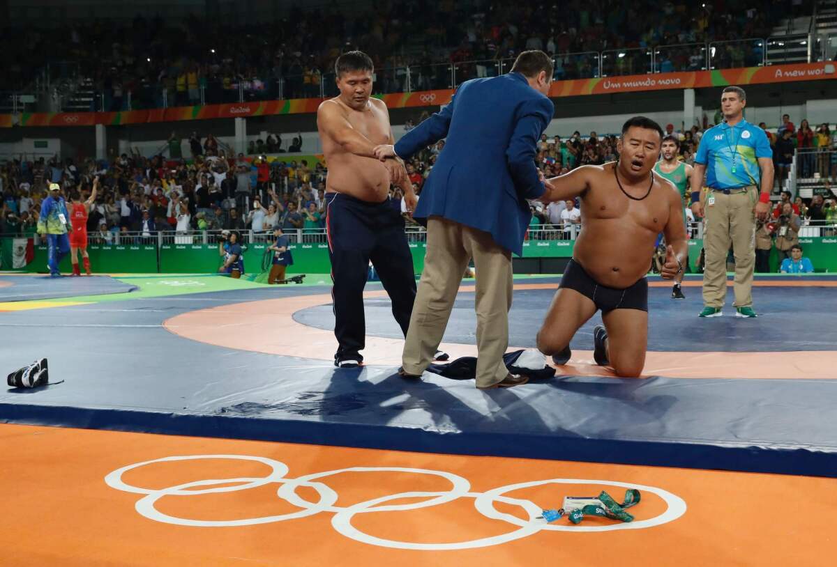 Mongolia wrestling coaches take off most of their clothes after wrestler Ganzorigiin Mandakhnaran lost his bronze medal match.