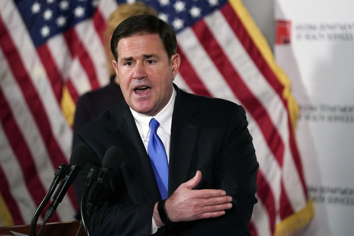 FILE - In this Dec. 2, 2020, file photo, Arizona Republican Gov. Doug Ducey answers a question during a news conference in Phoenix. Officials in the city of Tucson plan to ignore Arizona's new "Second Amendment sanctuary" law that bars state and local governments from enforcing certain federal gun regulations, possibly setting up a court fight as a growing number of cities and counties in the U.S. declare themselves similar firearm havens. The new action came after GOP Gov. Ducey signed a bill in April 2021, declaring that Arizona is a so-called Second Amendment sanctuary. (AP Photo/Ross D. Franklin, Pool, File)