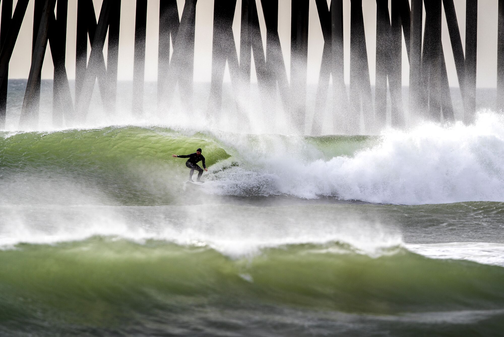 Jan. 19: Surfers ride waves at the Huntington Beach Pier.