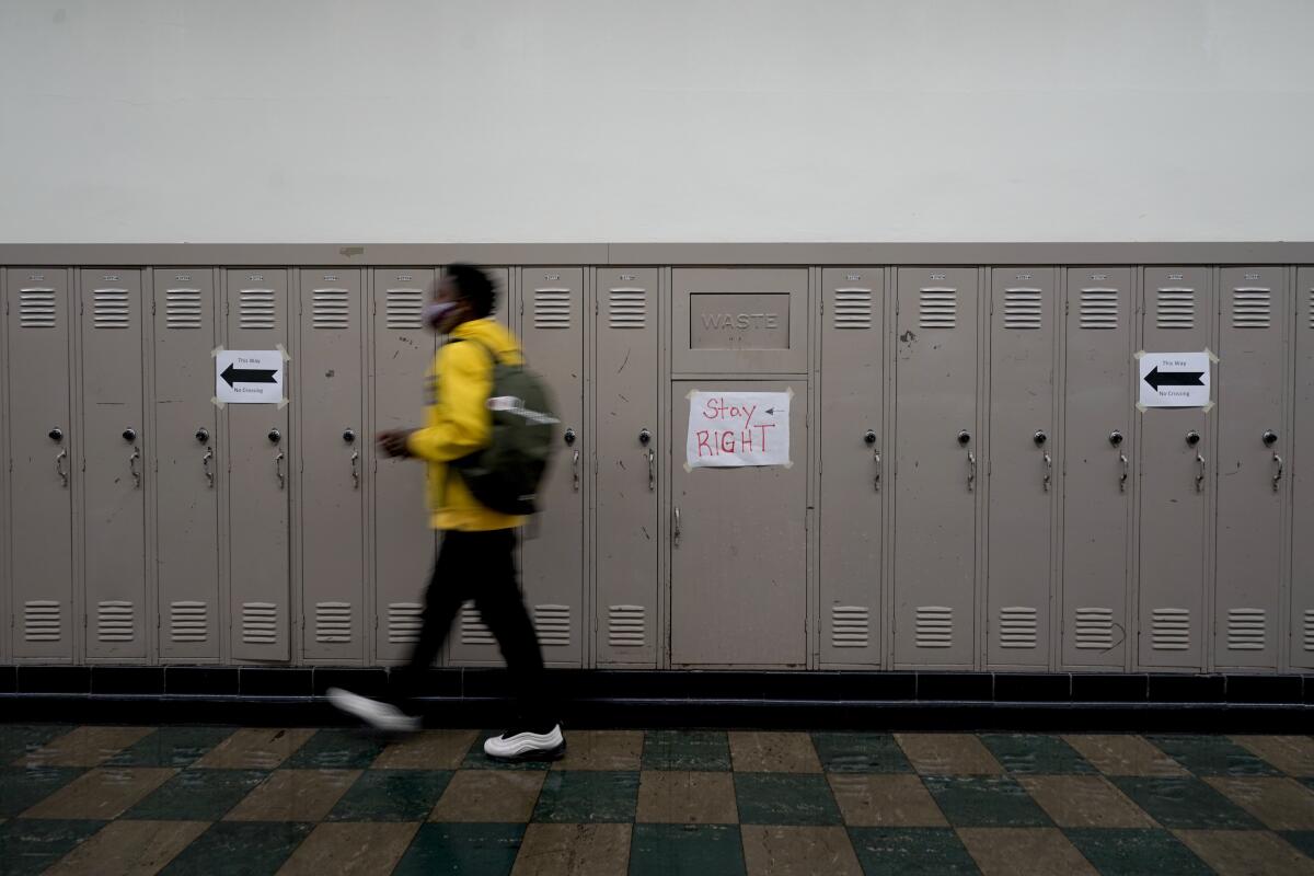 Un alumno camina por el pasillo de una escuela