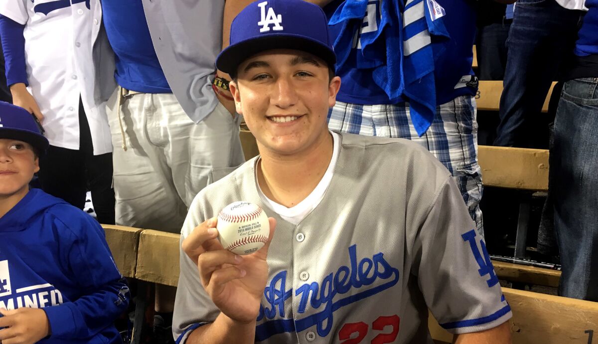 Drew Nash displays the ball that Yasiel Puig hit for a three-run home run in the sixth inning of Game 4 on Saturday night.