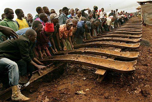 In the Kibera slum of Nairobi, protesters turn over a section of railroad tracks after breaking the ties. Some of the male residents had spent the day damaging the tracks that lead from Nairobi to Uganda. They said they didn't want President Kibaki to use the railroad to transport Ugandan troops to fight against them. Police responded by opening fire and killing at least six people in one of the bloodiest days of the ongoing protests.