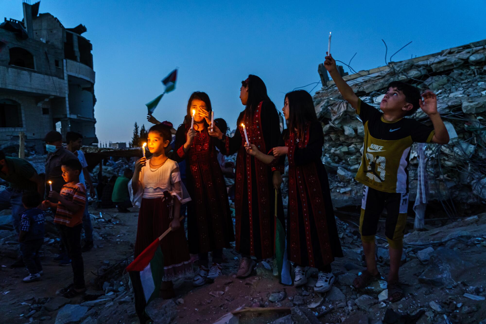 Palestinian children hold up candles and weep as they attend a candlelight vigil in Gaza City. 