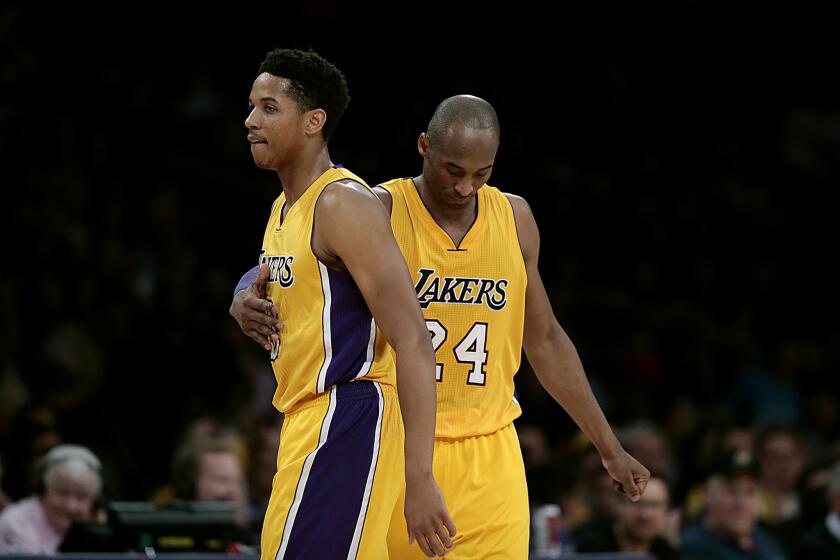 Kobe Bryant offers a subtle tap to teammate Anthony Brown as he leaves the court during second half of the Lakers' 112-93 loss to the Sacramento Kings on Jan. 20.