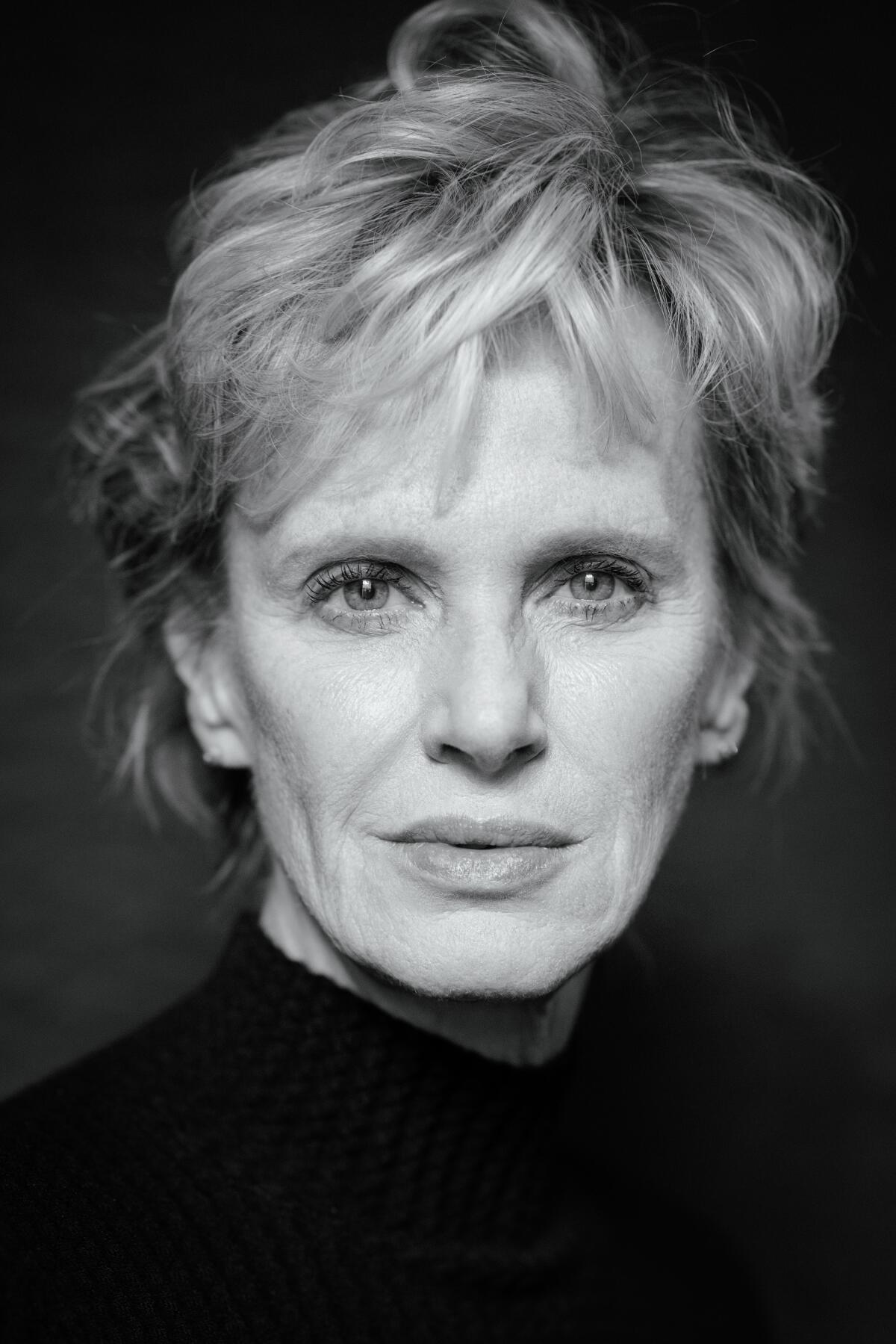 A woman in a dark turtleneck top.