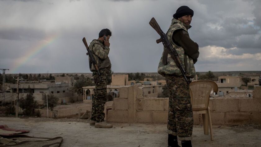 Kurdish militia keep watch in Baghouz al Fawqani, Syria, on Sunday as fighting continues in an area where Islamic State militants are said to remain.
