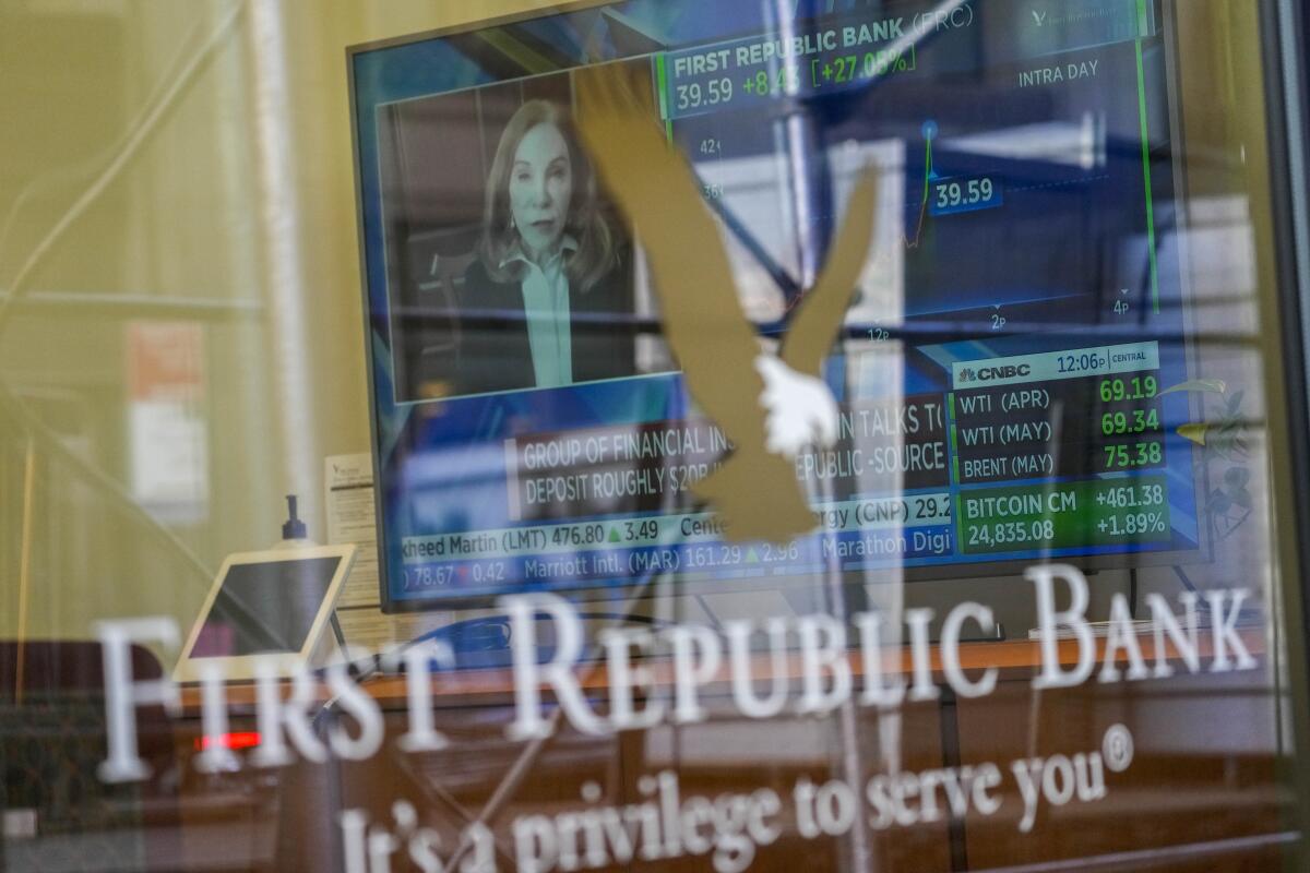 A television screen displaying financial news behind a window reading "First Republic Bank."