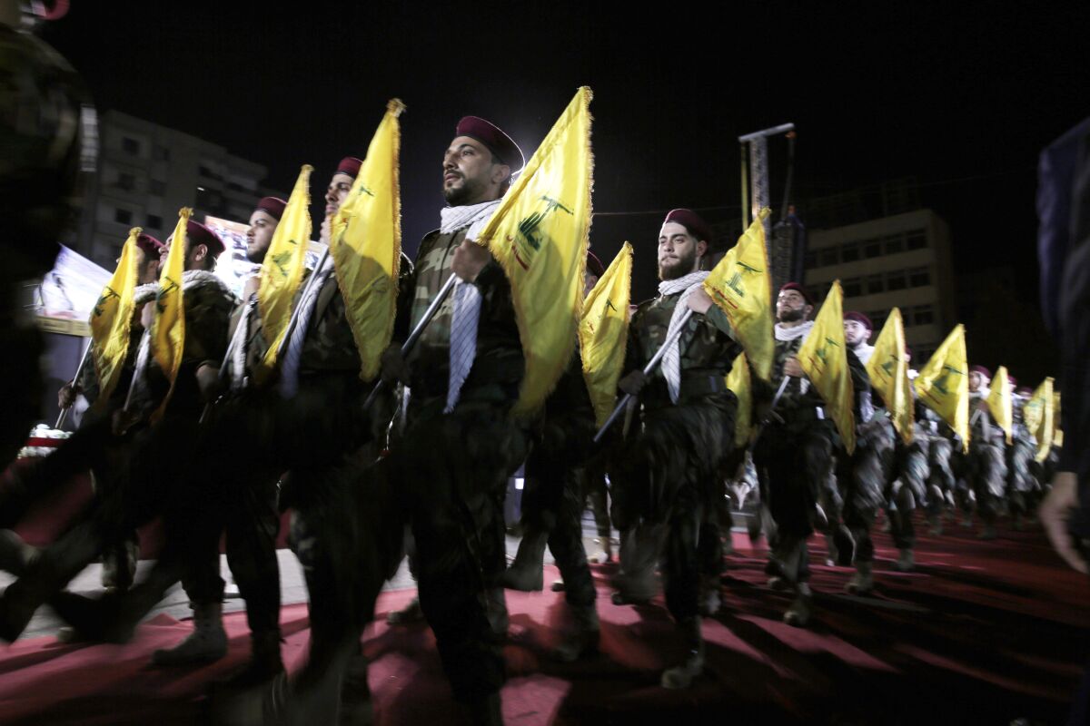FILE - In this May 31, 2019 file photo, Hezbollah fighters march at a rally to mark Jerusalem day or Al-Quds day, in the southern Beirut suburb of Dahiyeh, Lebanon. On Monday, Oct. 18, 2021, Hezbollah leader Sheik Hassan Nasrallah revealed that his militant group has 100,000 trained fighters. (AP Photo/Hassan Ammar, File)