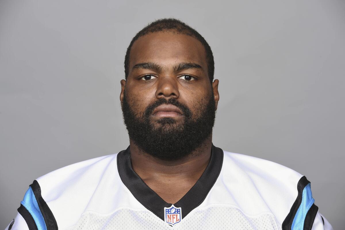 Michael Oher poses for a headshot wearing a white and blue Carolina Panthers jersey