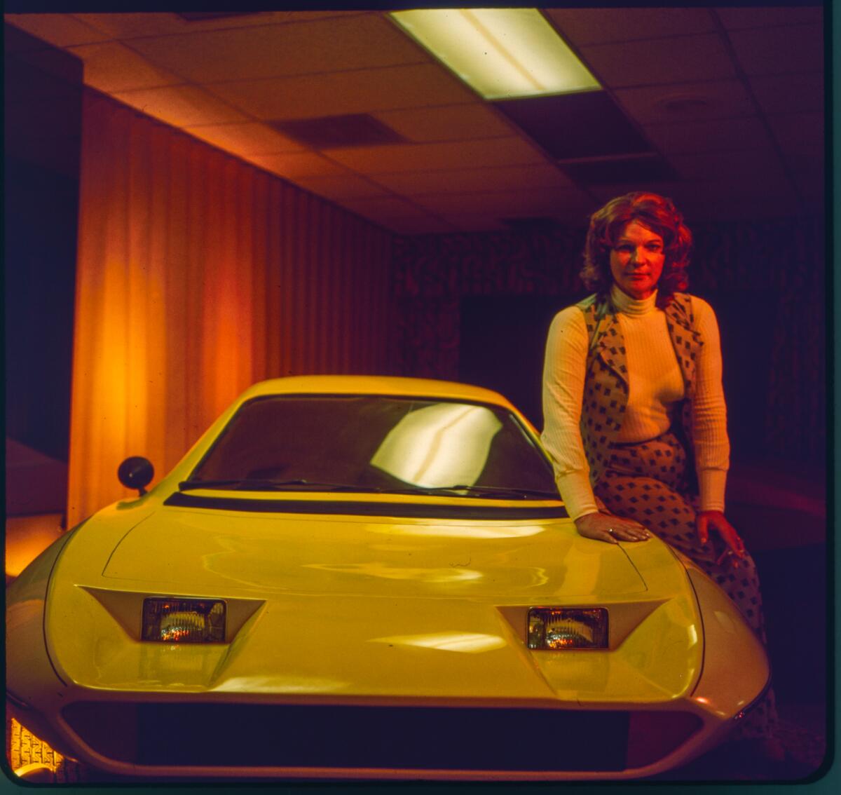 Elizabeth Carmichael leaning on a bright yellow model of her Dale automobile
