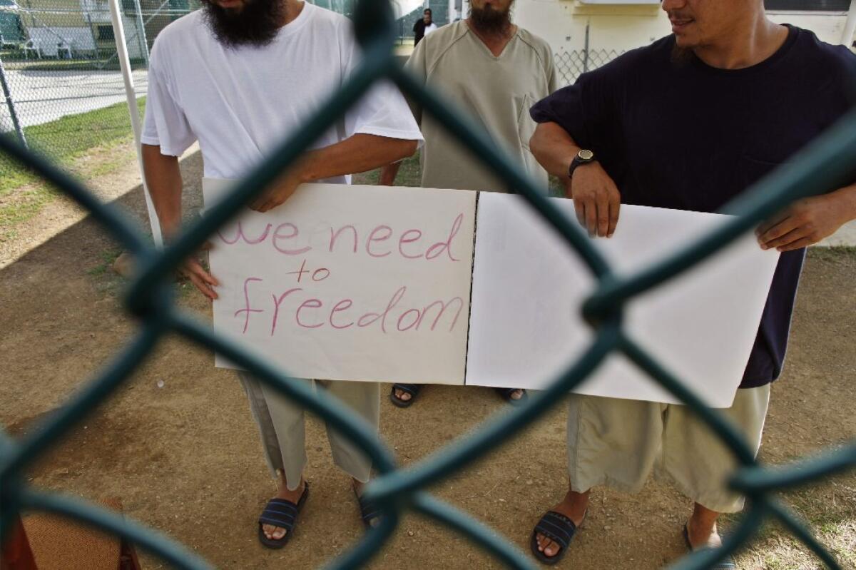 Chinese Uighur Guantanamo detainees -- seen here in 2009, who at the time were cleared for release but had no country to go to -- show a homemade note to visiting journalists at Guantanamo Bay, Cuba. It was announced on Dec. 31 that Slovakia has accepted the last three Chinese Uighur prisoners from Guantanamo Bay who had posed a difficult resettlement challenge.