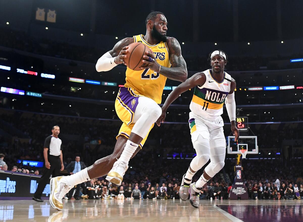 Lakers' LeBron James drives to the basket on New Orleans Pelicans' Jrue Holiday in the second quarter at Staples Center on Tuesday.
