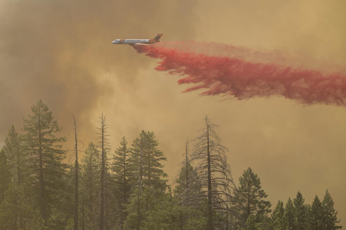 Un avión arroja retardante de incendios sobre el incendio Park, cerca de Forest Ranch, California