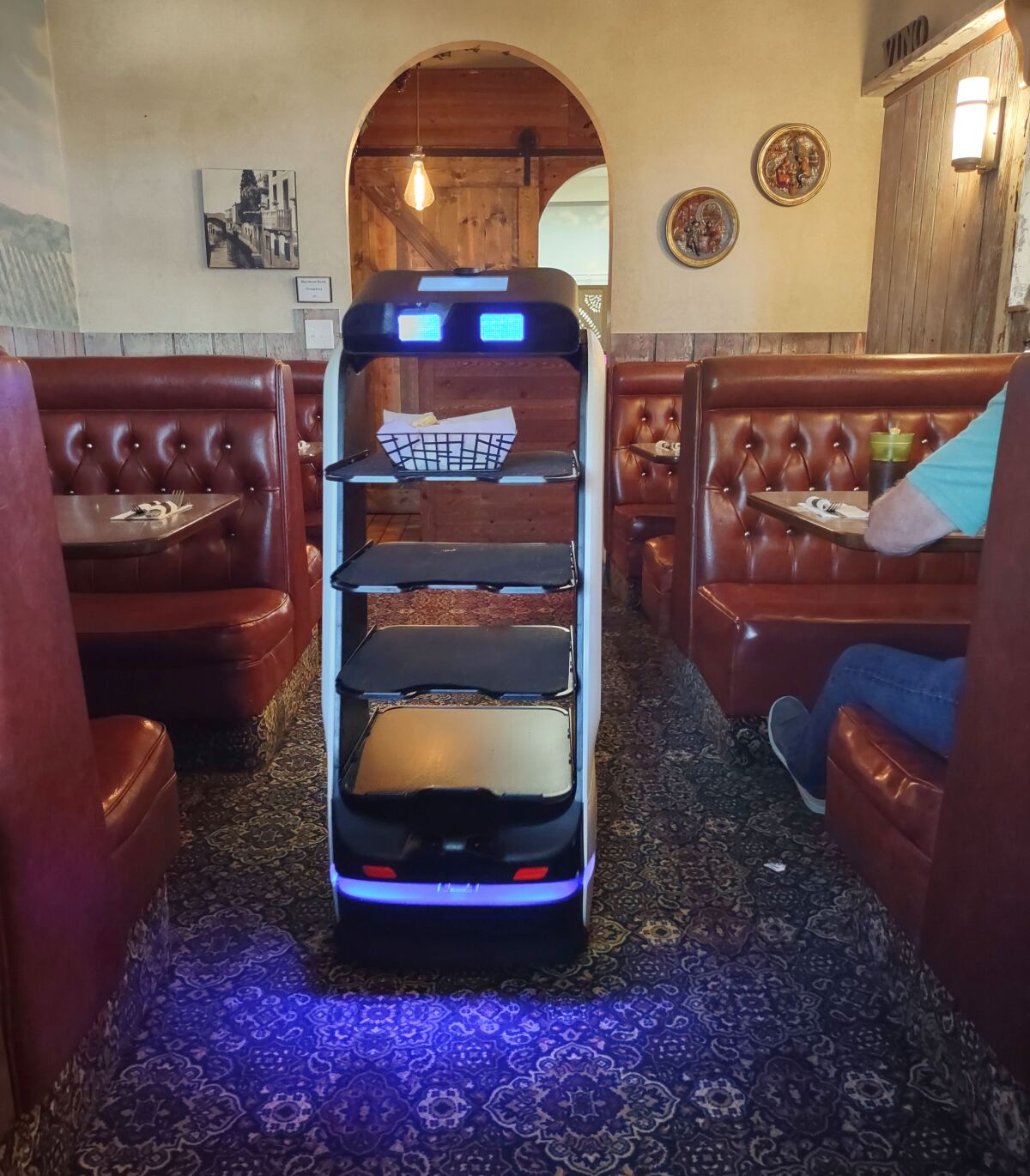 Rosie the robot delivers a basket of garlic bread to guests at Mamma Ramona’s restaurant.