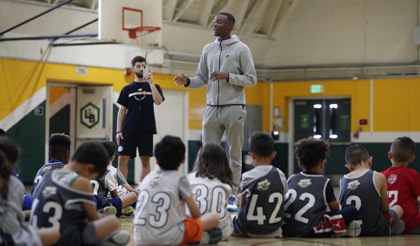 Austin Pope, formerly of Burbank High and currently working out with NBA teams with the goal of being an NBA player himself, stands at 6' 5" and towers over the seated basketball campers in the Breakthrough Sports Basketball Camp at Luther Burbank Middle School in Burbank on Thursday, June 13, 2019. This is the first year of the camp, and Austin Pope is a special guest.