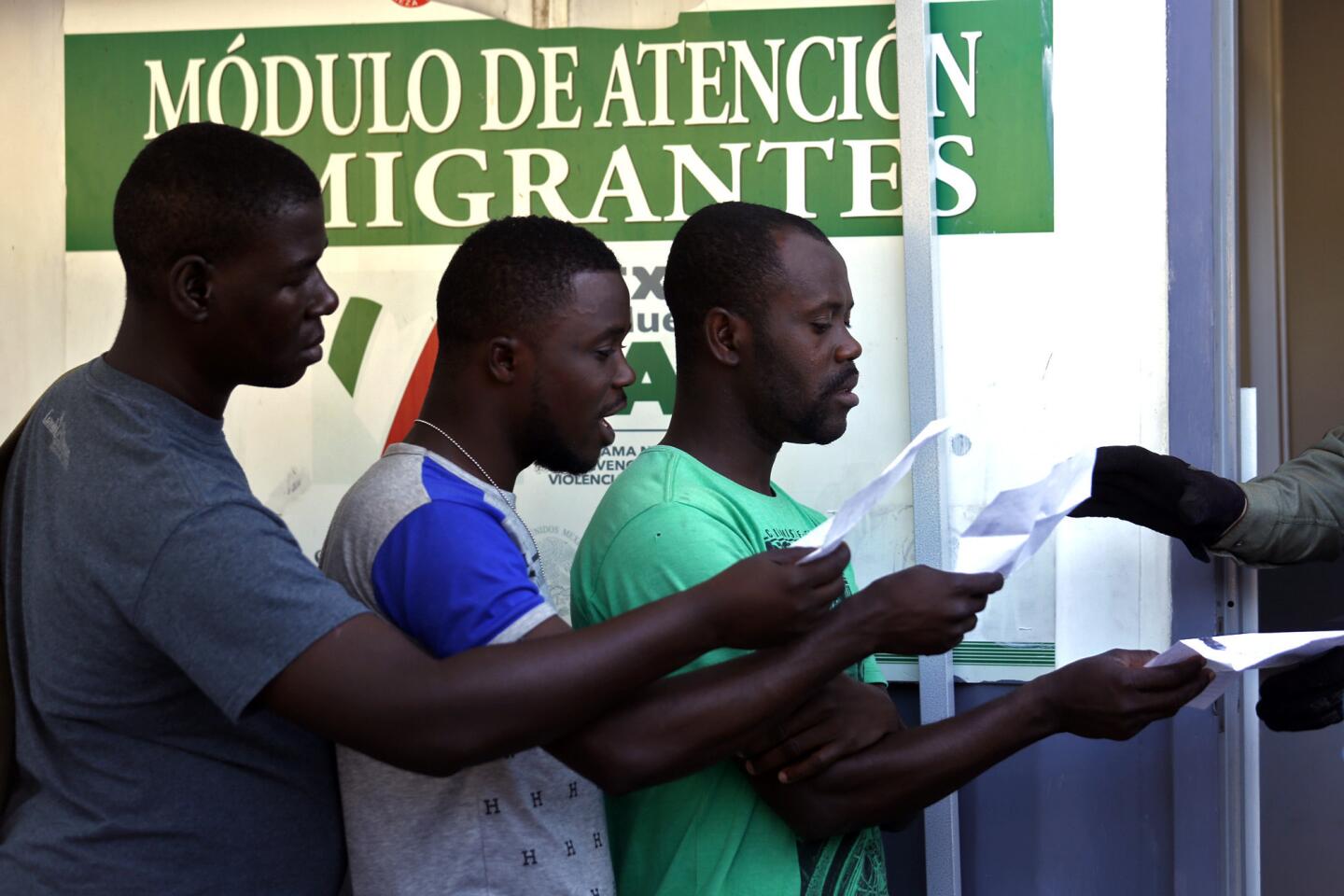 Haitian migrants hand their paperwork to a Mexican official at a makeshift office set up near the U.S. border.