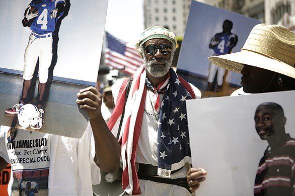 Illegal immigration protester Ted Hayes marches in downtown Los Angeles alongside Jamiel and Anita Shaw, the parents of Jamiel Shaw II, 17, a black athlete who was shot and killed in March by an alleged gang member who was in the country illegally. Marchers carried American flags and signs that read, Justice for Jamiel. The march and rally at City Hall came days after a judge ruled that Pedro Espinoza, 19, will stand trial in the teenager's slaying.