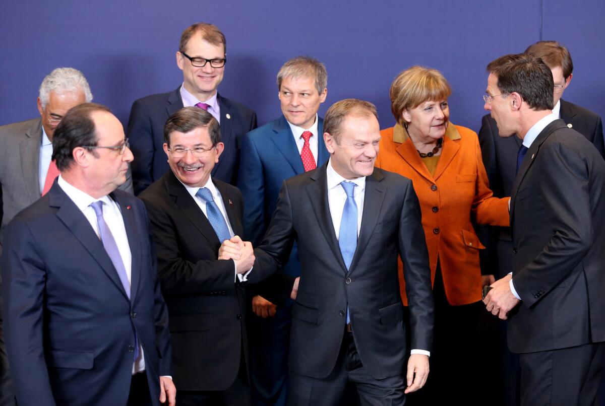 European Council President Donald Tusk, front center right, shakes hands with Turkish Prime Minister Ahmet Davutoglu in Brussels on March 7, 2016.