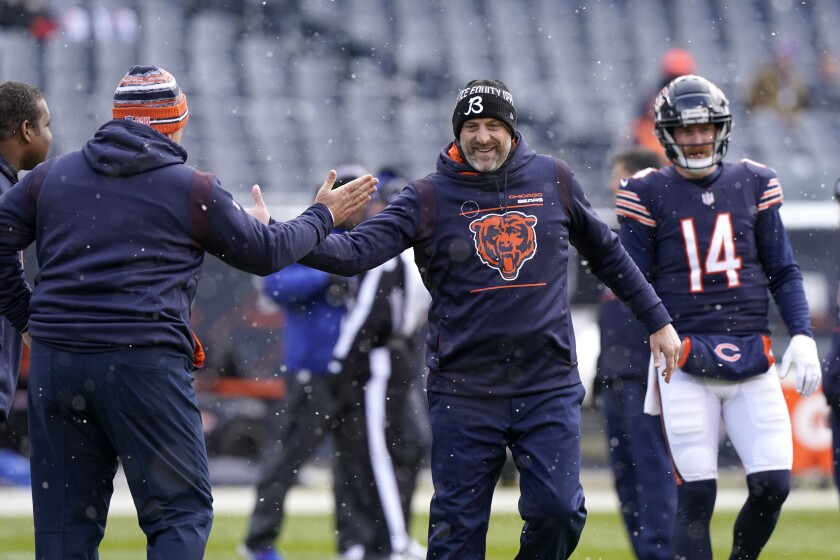 Chicago Bears head coach Matt Nagy, center, greets an assistant coach as the Bears warm up before an NFL football game against the New York Giants Sunday, Jan. 2, 2022, in Chicago. (AP Photo/Nam Y. Huh)