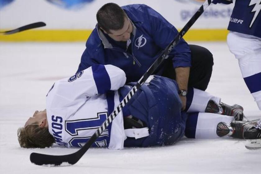 Tampa Bay Lightning center Steven Stamkos is attended to on the ice after banging into the goalpost during the second period of a game against the Boston Bruins on Monday.