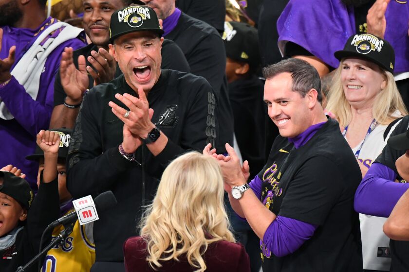 ORLANDO, FLORIDA OCTOBER 11, 2020- Lakers GM Rob Pelinka, left, and head coach Frank Vogel celebrate with owner Jeannie Buss, center, after winning the NBA Championship in Game 6 of the NBA FInals in Orlando Sunday. (Wally Skalij/Los Angeles Times)