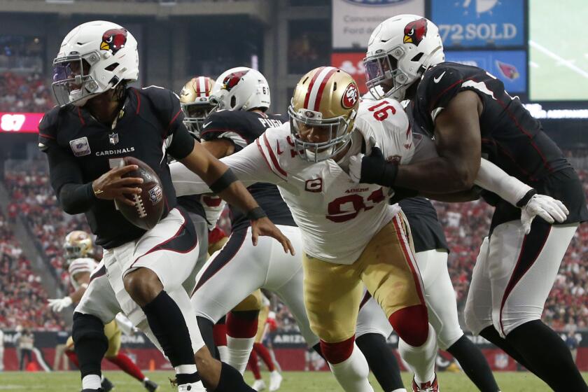 Arizona Cardinals quarterback Kyler Murray (1) eludes the reach of San Francisco 49ers defensive end Arik Armstead.