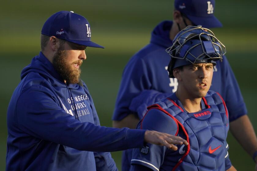 Los Angeles Dodgers pitcher Jimmy Nelson, left, talks with Dodgers catcher Austin Barnes after the two warm up in the bullpen prior to a spring training baseball game against the Chicago Cubs Thursday, March 4, 2021, in Phoenix. (AP Photo/Ross D. Franklin)