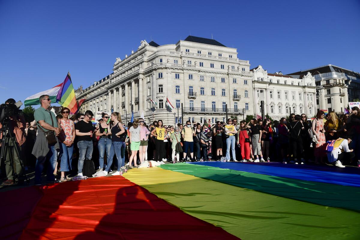 People unfurl a rainbow flag during an LGBT rights demonstration in front of the Hungarian Parliament building in Budapest