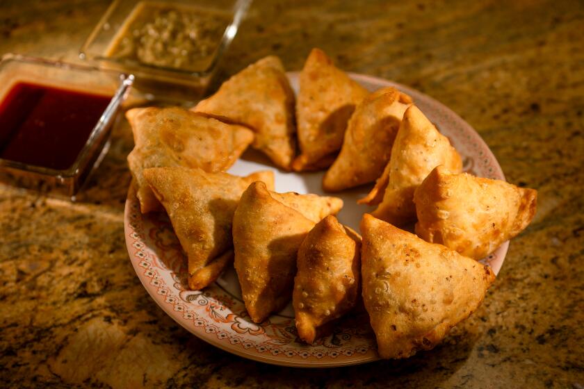 Prepared samosas with tamarind and mint chutney alongside from Cali Tardka home restaurant in Riverside on Friday, July 21, 2023. (Paul Rodriguez / For The Times)