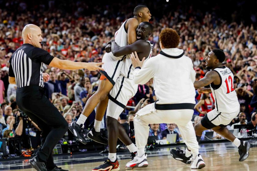 Houston, TX - April 1: San Diego State Aztecs guard Lamont Butler is embraced by teammate Aguek Arop after hitting the game winning shot at the buzzer to send the team to the national championship during the semifinal round of the 2023 NCAA Men's Basketball Tournament played between the San Diego State Aztecs and the Florida Atlantic Owls at NRG Stadium on Saturday, April 1, 2023 in Houston, TX. (K.C. Alfred / The San Diego Union-Tribune)