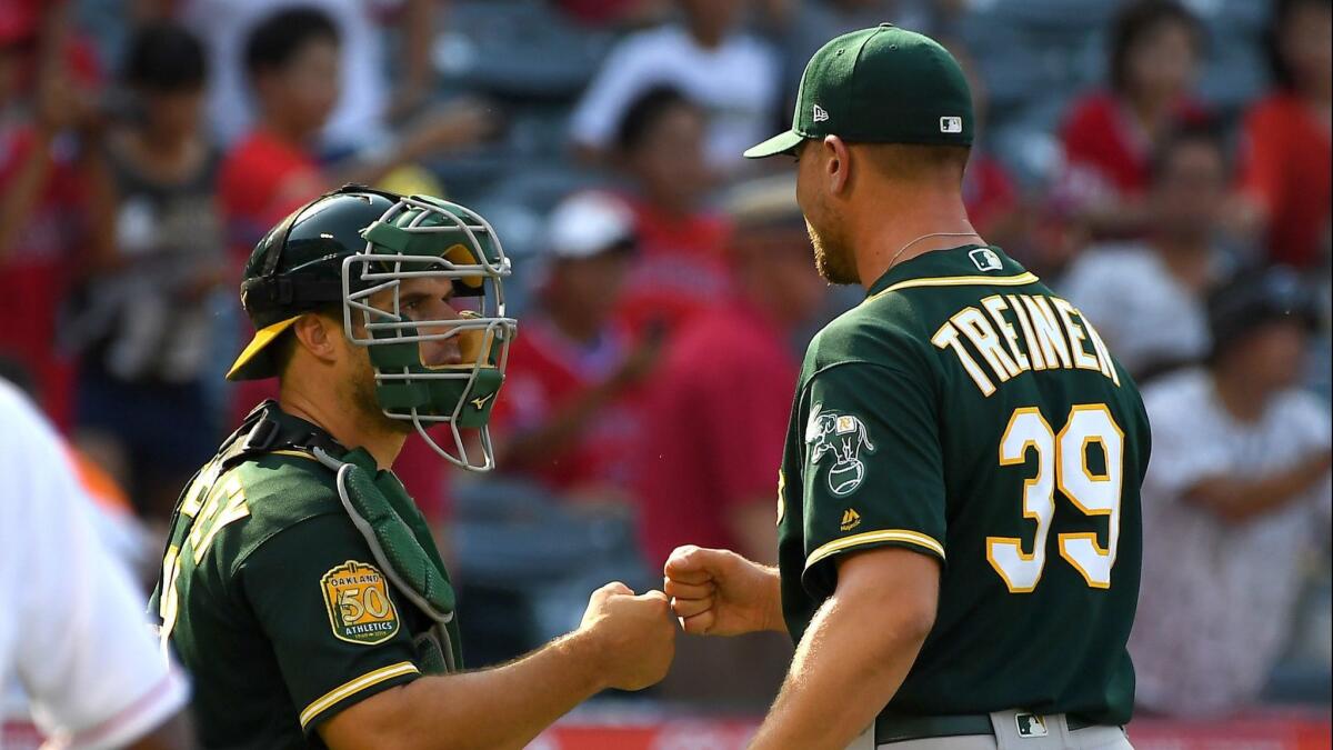 Closer Blake Treinen and catcher Josh Phegley get together after the Oakland Athletics' 8-7 victory over the Angels on Sunday.