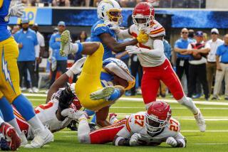 The Chargers' J.K. Dobbins (27) is upended near the goal line by the Chiefs' Chamarri Conner (27).