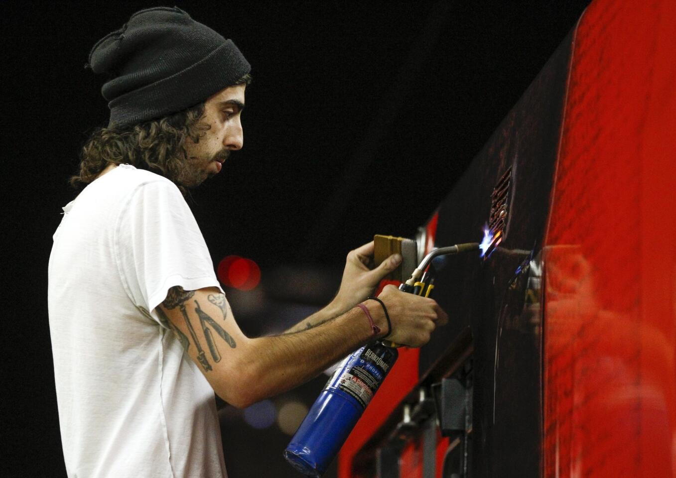 Nathan Parvizi, of Pixel imaging Media, uses a torch to stretch the self adhesive transit vinyl.