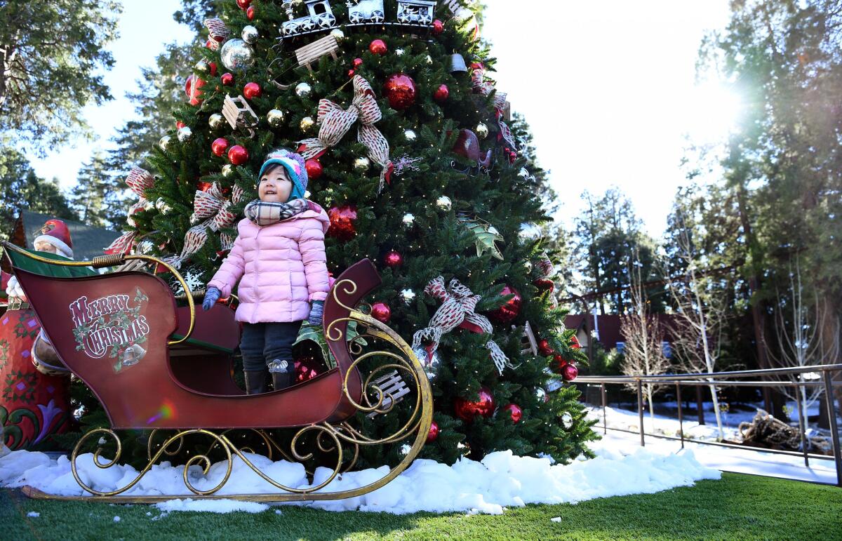 Coral Lin, 2, stands on a sleigh during opening day of Skypark at Santa's Village on Friday.