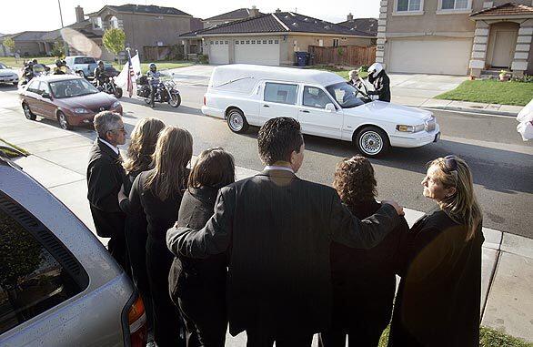 Relatives of Army Pfc. George Delgado of Palmdale, who was killed recently in Iraq, are grief-stricken this week as a hearse carries his body past his home. Delgado and three other GIs died one day after being hit by the blast from a roadside bomb in Baghdad. Now his family has to bear the unbearable.