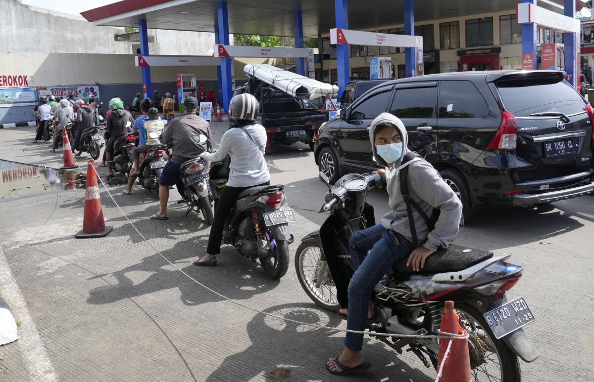Motorists queue up to fill up their tanks after the government announced an increase in fuel prices, at a gasoline station in Jakarta, Indonesia, Saturday, Sept. 3, 2022. Fuel prices increased by about 30 percent across Indonesia on Saturday after the government reduced some of the costly subsidies that have kept inflation in Southeast Asia's largest economy among the world's lowest. (AP Photo/Tatan Syuflana)
