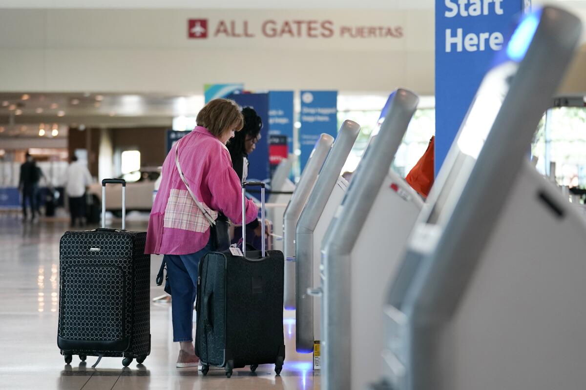 A traveler uses a kiosk at an airport