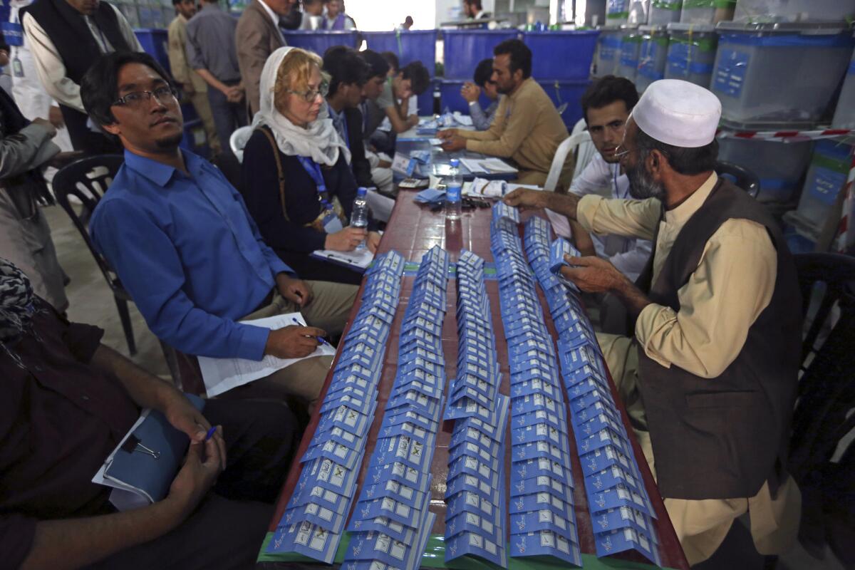 Afghan election commission workers sort ballots in Kabul on Monday for an audit of June's presidential runoff.