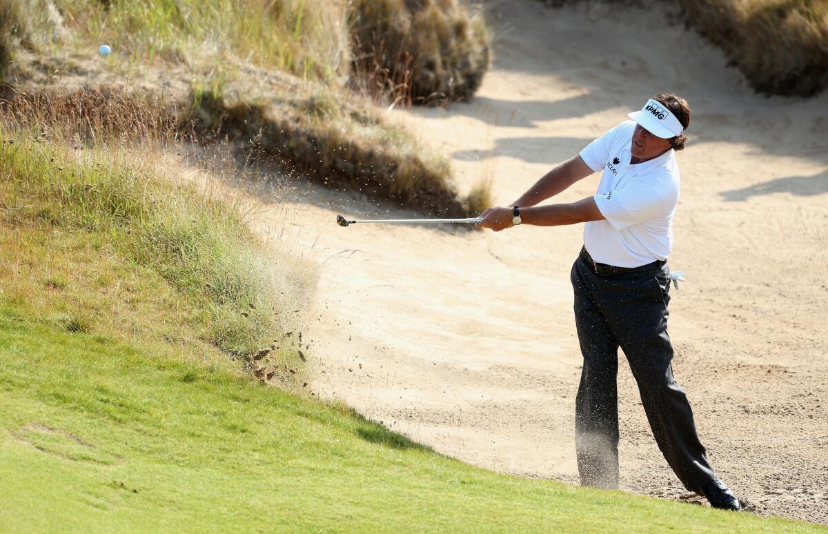 Phil Mickelson hits from out of a bunker on the 11th hole at the Scottish Open on Thursday.