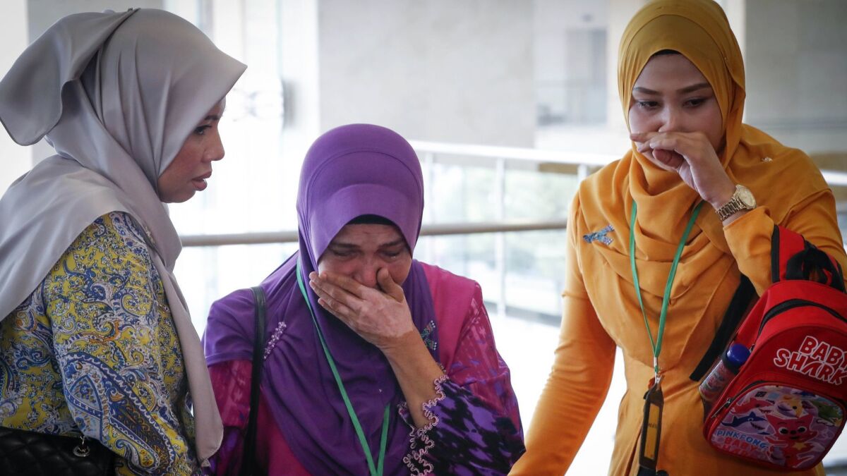 Sarah Nor, center, the mother of Norliakmar Hamid, a passenger on the missing Malaysia Airlines Flight 370, cries after listening to an investigation report on Monday.