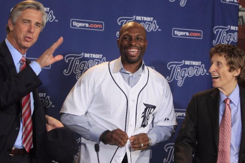Tigers owner Mike Ilitch, right, smiles with outfielder Torii Hunter and General Manager David Dombrowski, right, before a news conference in Detroit on Nov. 16, 2012.