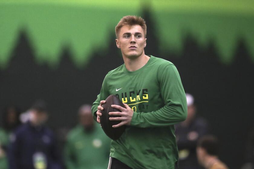 Oregon quarterback Bo Nix warms up before a position drill at the school's NFL Pro Day, Tuesday, March 12, 2024, in Eugene, Ore. (AP Photo/Amanda Loman)