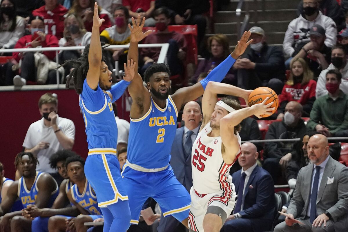 UCLA's Tyger Campbell and Cody Riley defend against Utah guard Rollie Worster.
